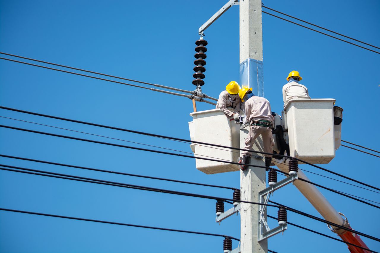 Services-03 Electricians wearing safety gear work on power lines in Nakhon Ratchasima, Thailand.