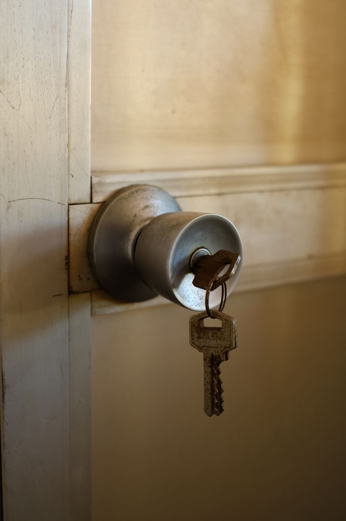 team-02 A key inserted in a metal door knob, symbolizing security and entry.