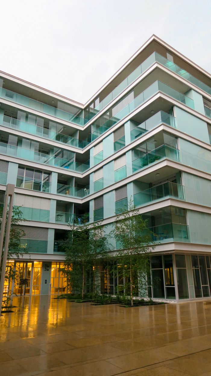 why-choose-us Contemporary residential building featuring glass balconies against an urban backdrop.