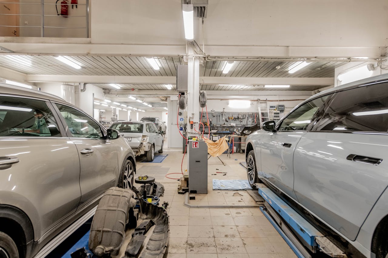 services-01 Interior of an automotive repair shop with cars undergoing maintenance and servicing.