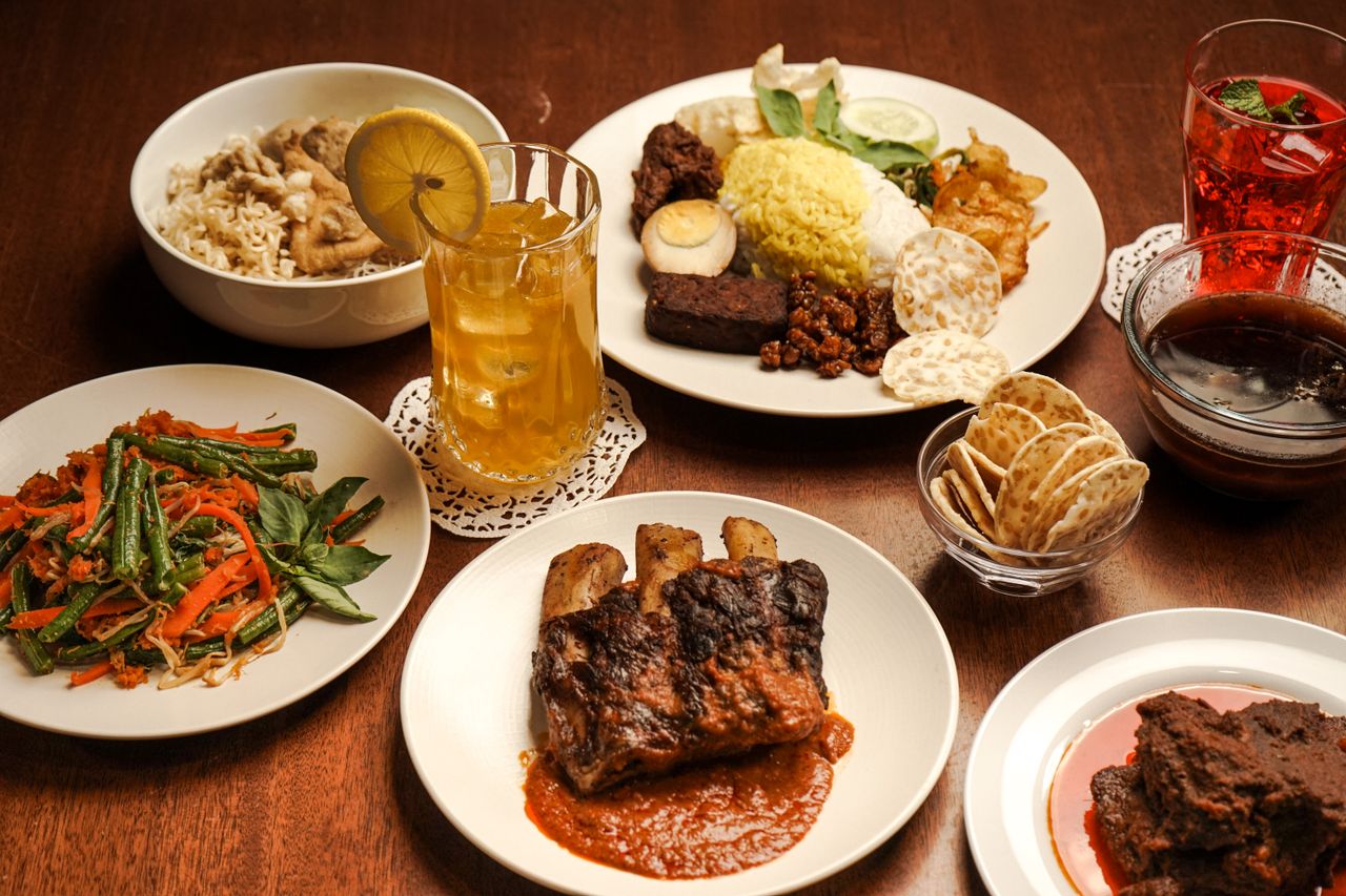 about-02 A variety of traditional Indonesian dishes served on a wooden table, perfect for a cultural dining experience.