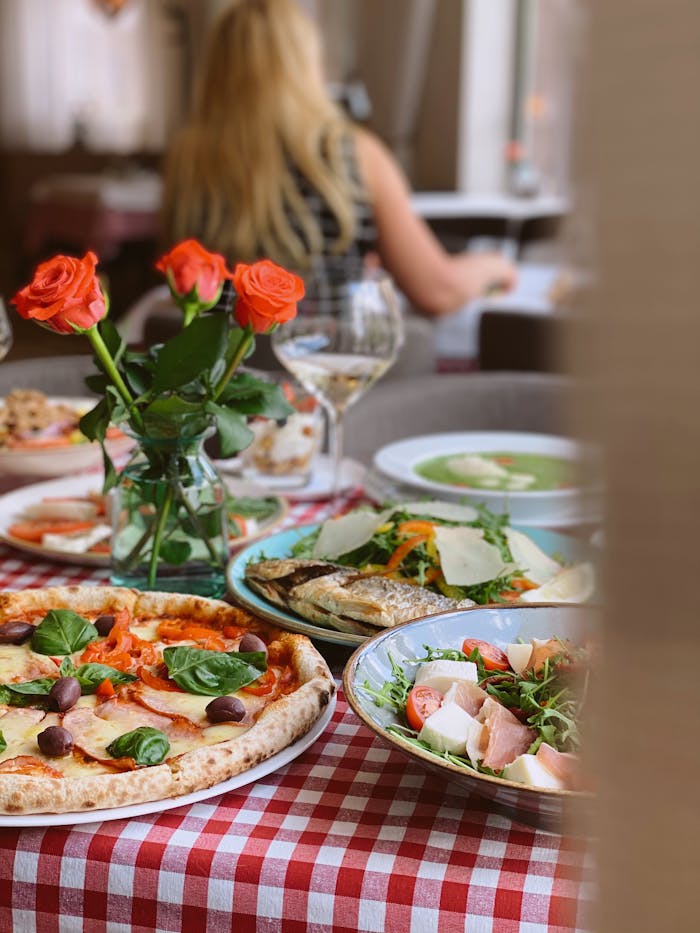 services-01 A vibrant display of Italian cuisine with pizza and wine on a checkered table. Perfect for dining concepts.
