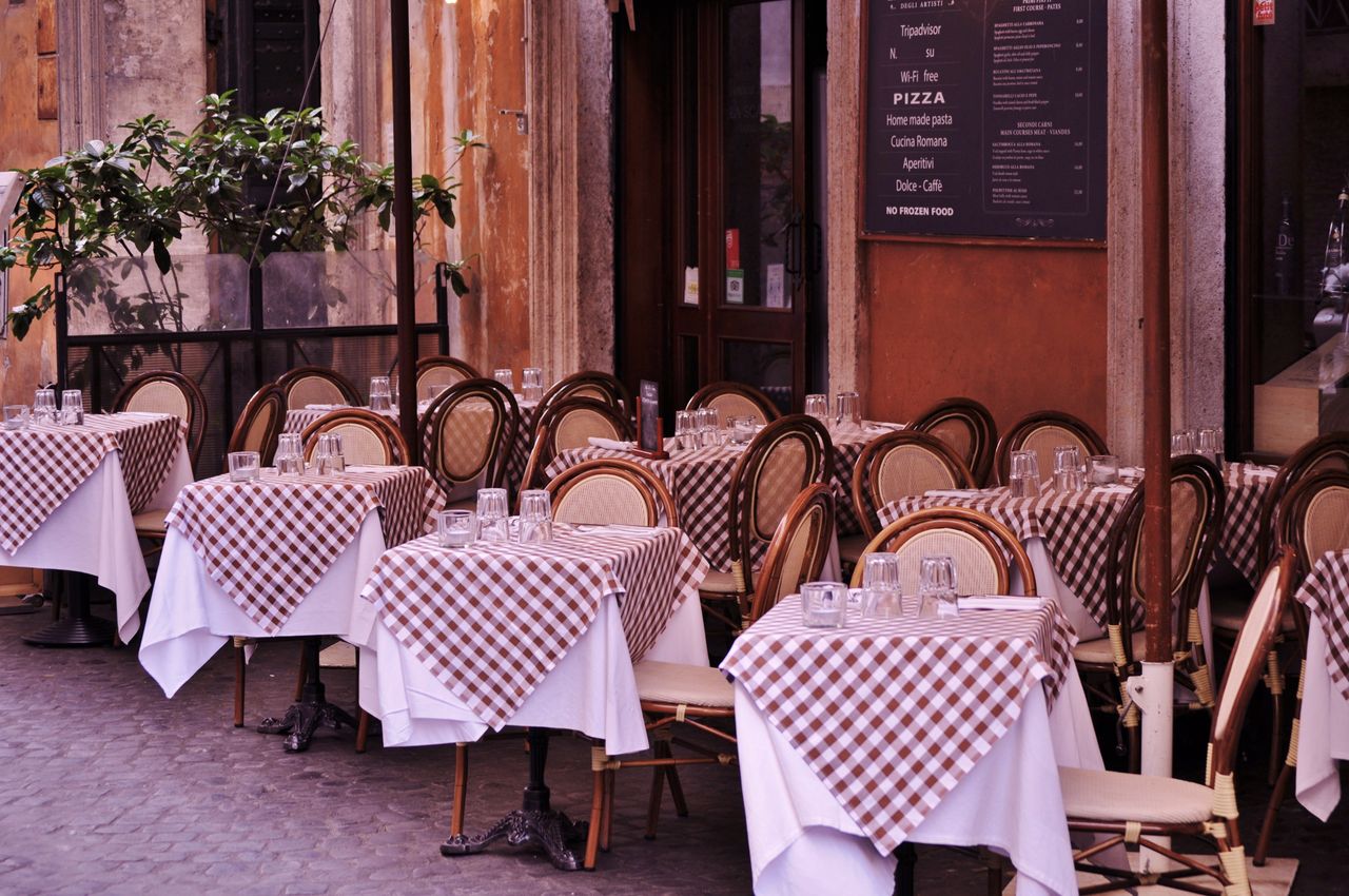 about-01 Cozy Italian restaurant with checkered tablecloths and inviting outdoor seating.