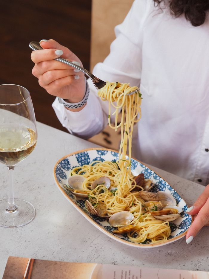 about-05 Capture of a gourmet seafood spaghetti meal paired with white wine.